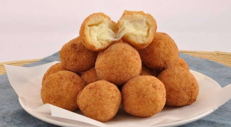 Bolinho de batata recheado com queijo, servido em um prato com ervas
