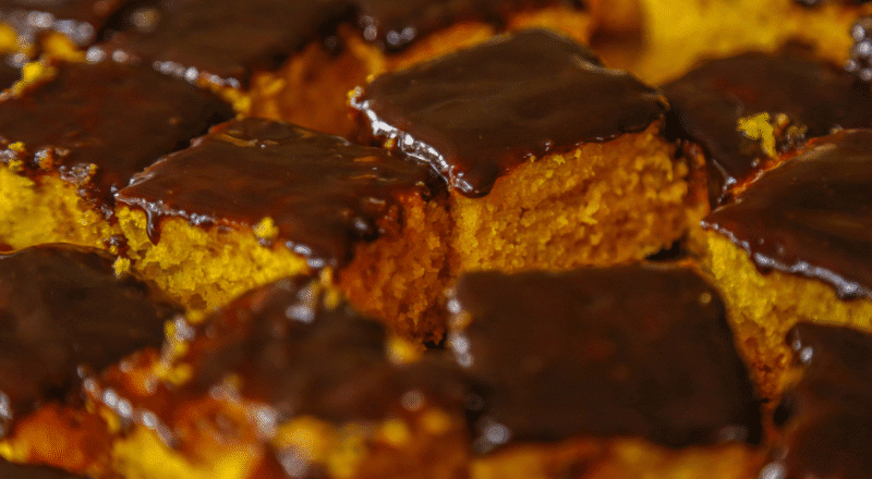 Bolo de cenoura macio com cobertura de chocolate em um prato decorado