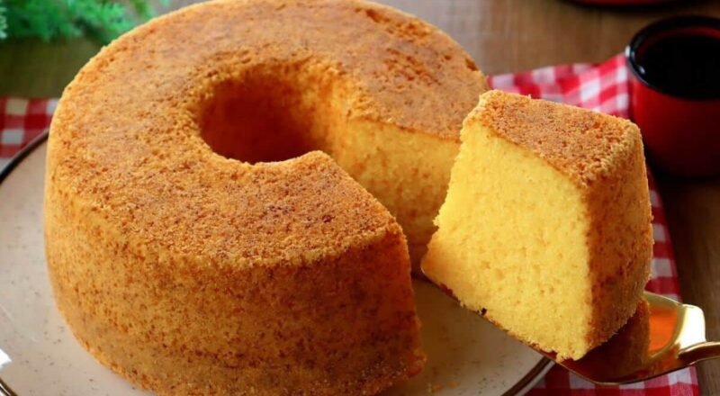 Bolo de fubá fofinho em um prato, acompanhado de uma xícara de café