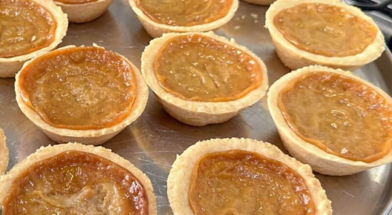 Empadinha de leite condensado saindo do forno, com aspecto dourado e recheio derretendo.