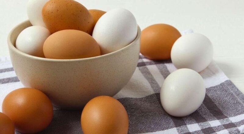 Ovo cozido descascado ao lado de um recipiente com gelo