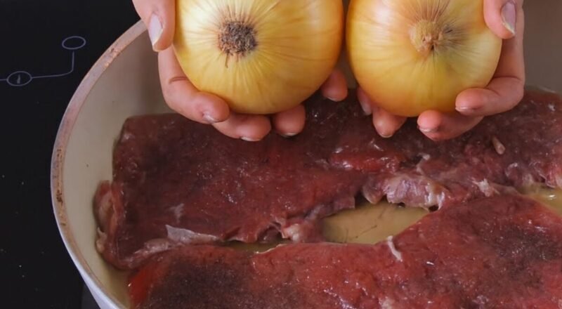 Bife acebolado suculento servido com cebolas douradas