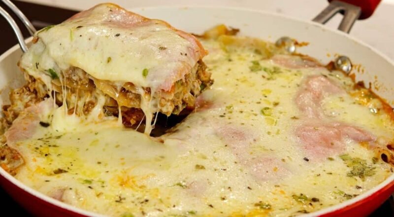 Lasanha de frigideira pronta com camadas de carne, molho e queijo derretido