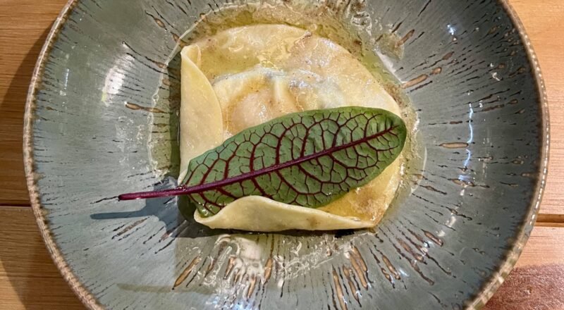 Prato de massa caramelle recheada com queijo de cabra e maçãs, finalizada com manteiga tostada