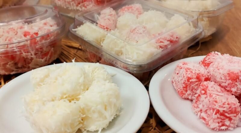 Bala de Coco Gelada em uma mesa com coco ralado ao fundo