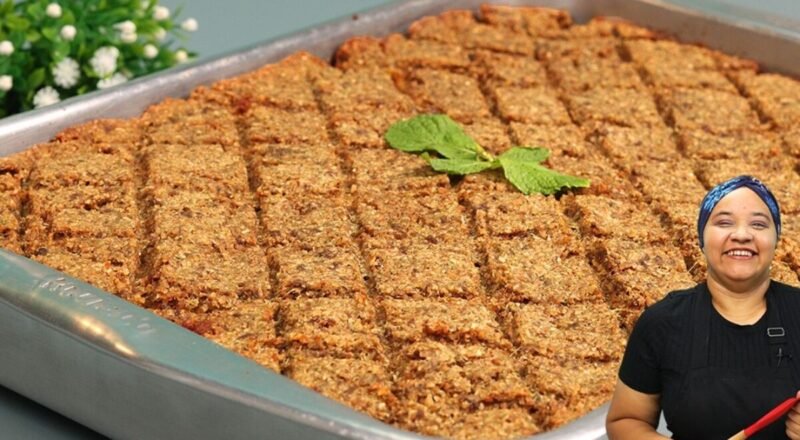 Quibe de forno recheado, dourado e suculento, servido em um prato com arroz e salada.