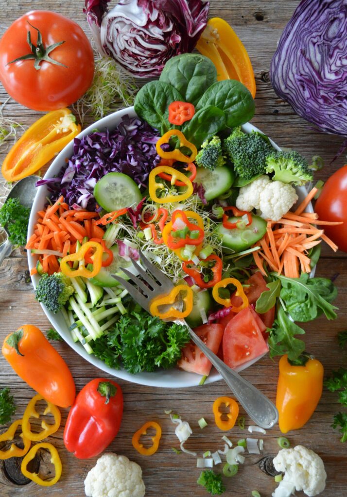 Prato colorido com uma variedade de frutas, verduras, grãos integrais e proteínas saudáveis