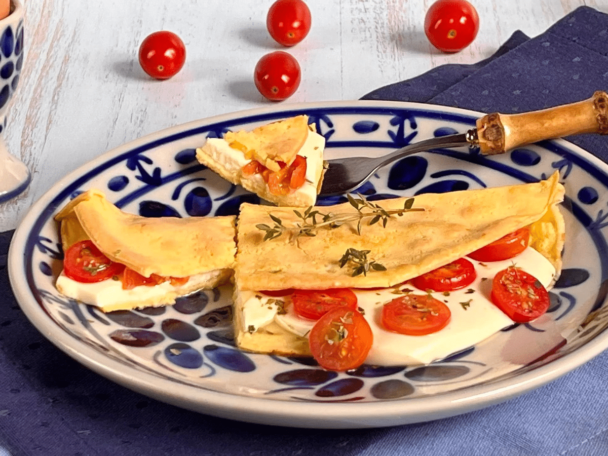 Crepioca de queijo com tomate e orégano servida em um prato