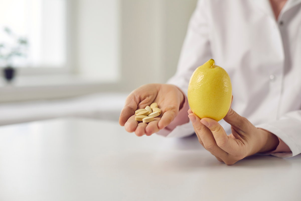 Ilustração de alimentos ricos em vitamina C, como acerola, morango, laranja e pimentão amarelo, simbolizando a prevenção do escorbuto.